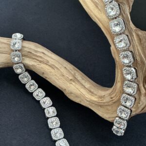 2 identical clear crystal halo bracelets draped over a driftwood branch