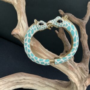 KJL giraffe blue white clamper perched on a driftwoodbranch with black background