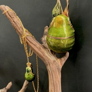 Edgar Berebi pear box and necklace perched and hung from a branch with black background