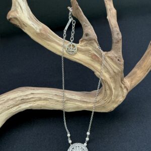 Trifari Silver tone pendant necklace hung on a branch with black background
