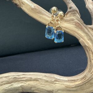 Park Lane pierced earrings gold tone hung on a branch with black background