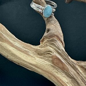 Larimar sterling ring hung on a branch with black background