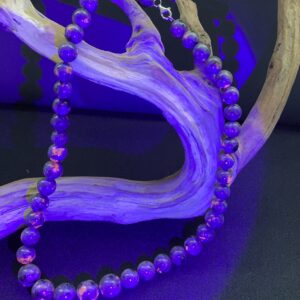 Yooperlite glowing graduated beaded necklace draped on a branch