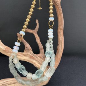 BushkaBlue original raw glass and trade beaded necklace draped over a branch with black background