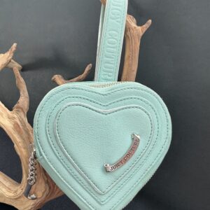 Aqua heart shaped wristlet hung on a branch with black background
