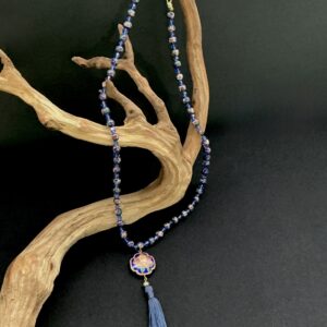 Cloisonne and crystal necklace on a branch with black background