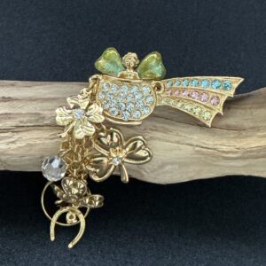 Kirk's folly pot of gold brooch perched on a piece of wood with a black background