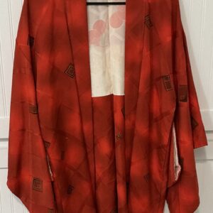 Red haori on a hanger with a white cabinet background