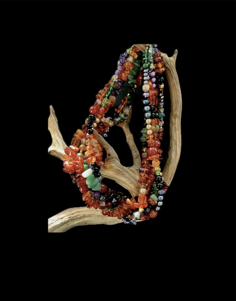 Vintage wearable art jewelry collection of colorful beads on driftwood