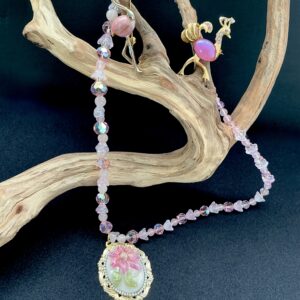 Curated wearable art: pink flamingo necklace and brooch on driftwood
