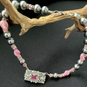 Handmade necklace with gray faux pearls, pink glass beads, and ornate silver filigree pendant with faceted center glass pink stone