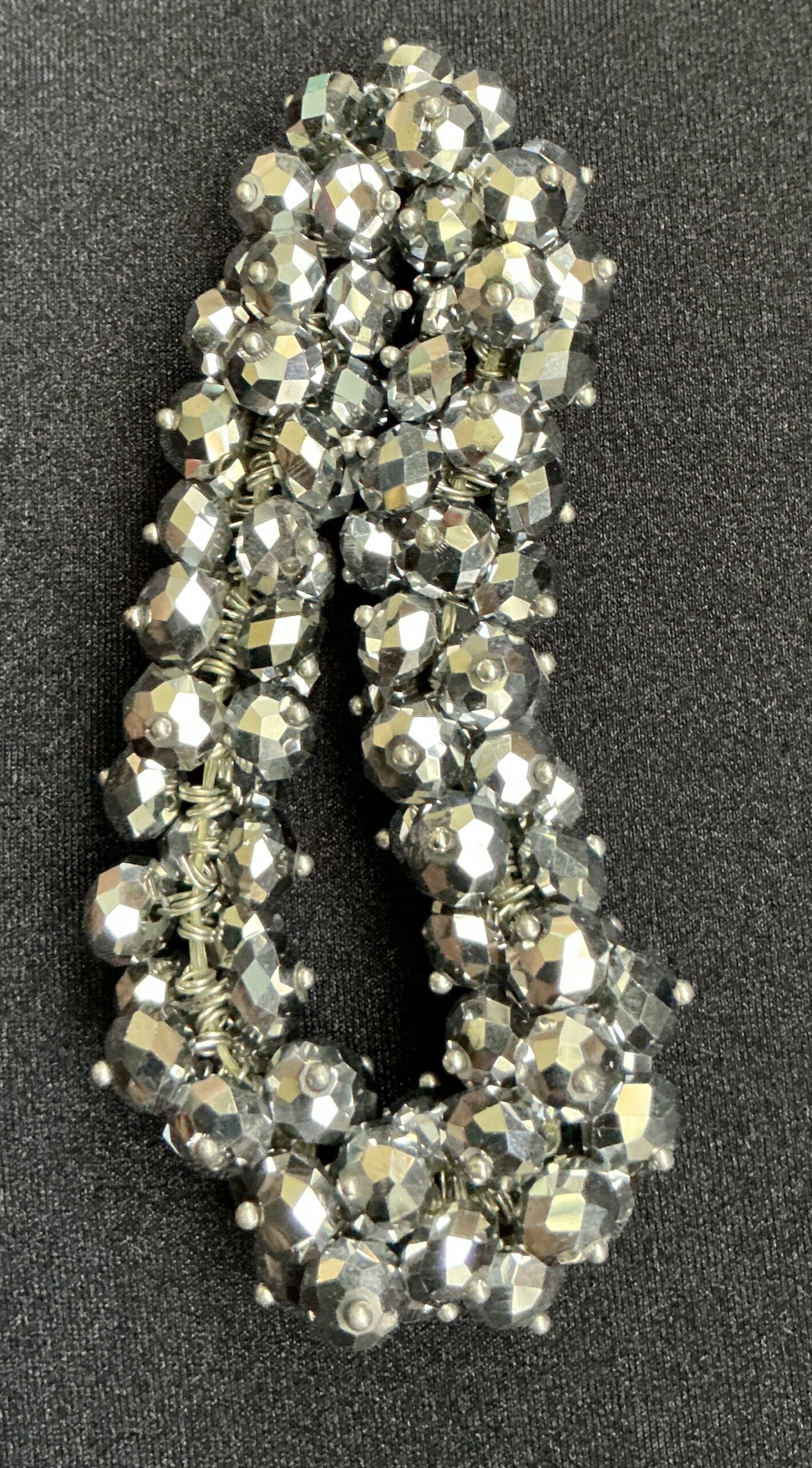 Close-up of a sparkly silver beaded bracelet with faceted beads