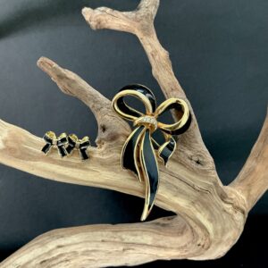 Gold and black enamel bow brooch and earrings on driftwood