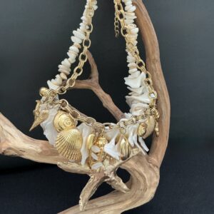 Layered Gold seashell necklace with white shell beads on driftwood